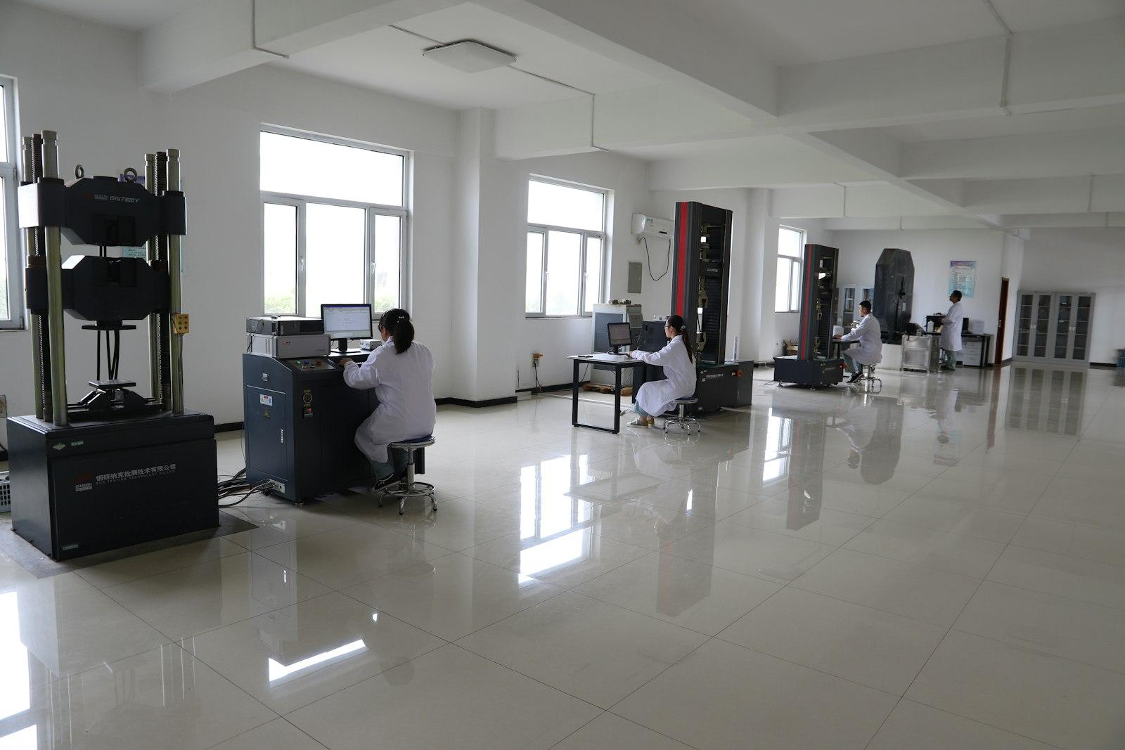 Engineers at workstations in a materials testing lab with load-testing machines