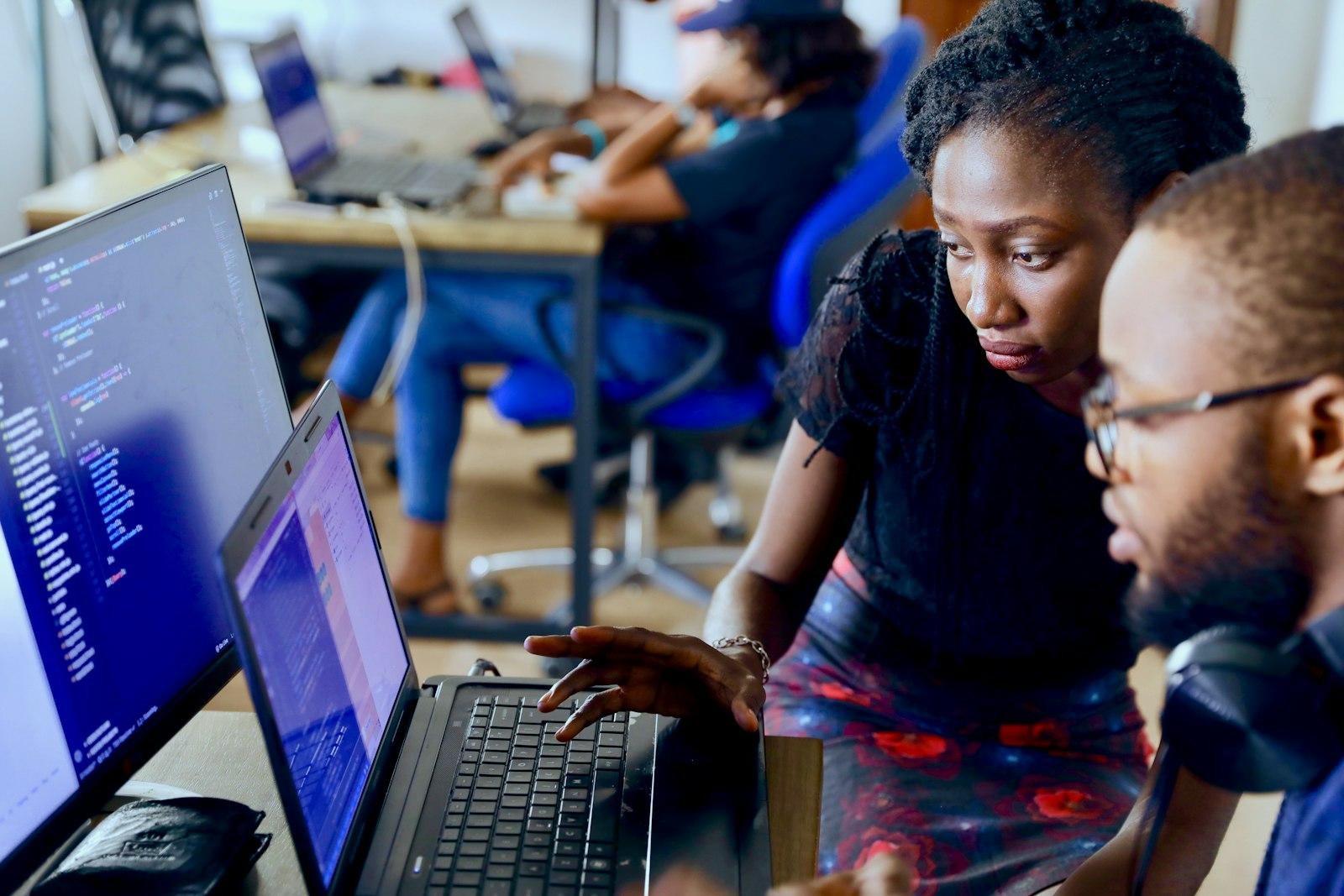 Two developers working through code together at a laptop