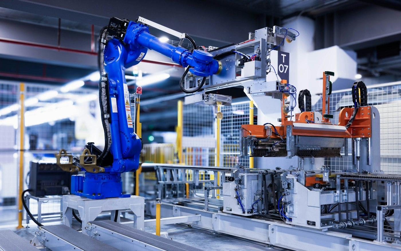 Blue industrial robot arm in a factory cell